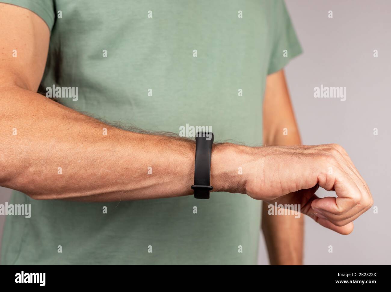 Man looking at fitness bracelet for walking steps, running distance, heart rate or sleep patterns monitoring. Healthy lifestyle concept. Tool for daily activity and health data monitoring. photo Stock Photo