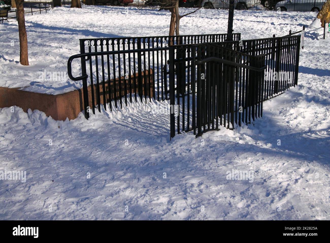 A black fence on the white snow in a park Stock Photo - Alamy