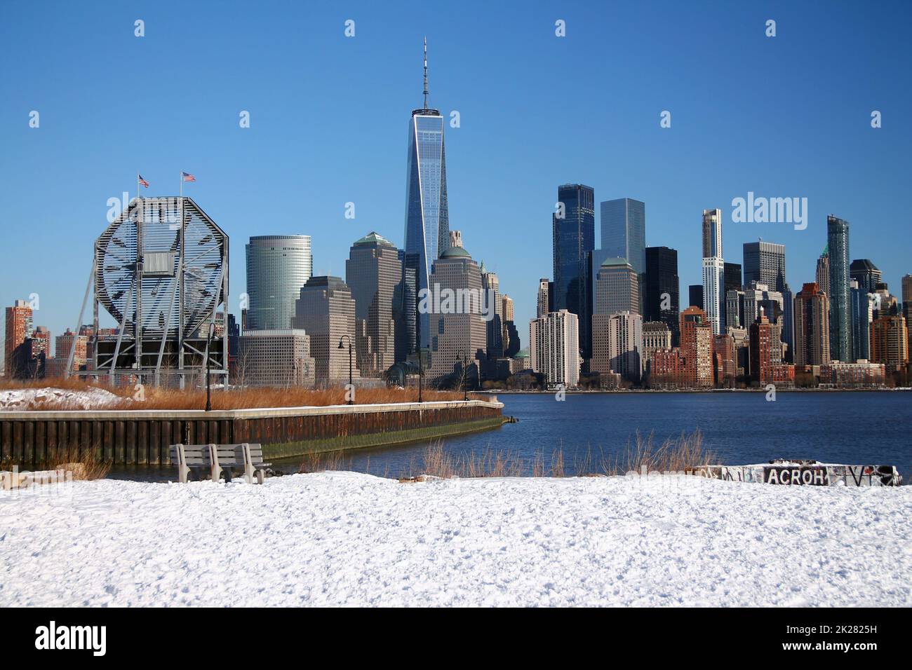 The bench and the big clock looking at downtown Manhattan with the snow