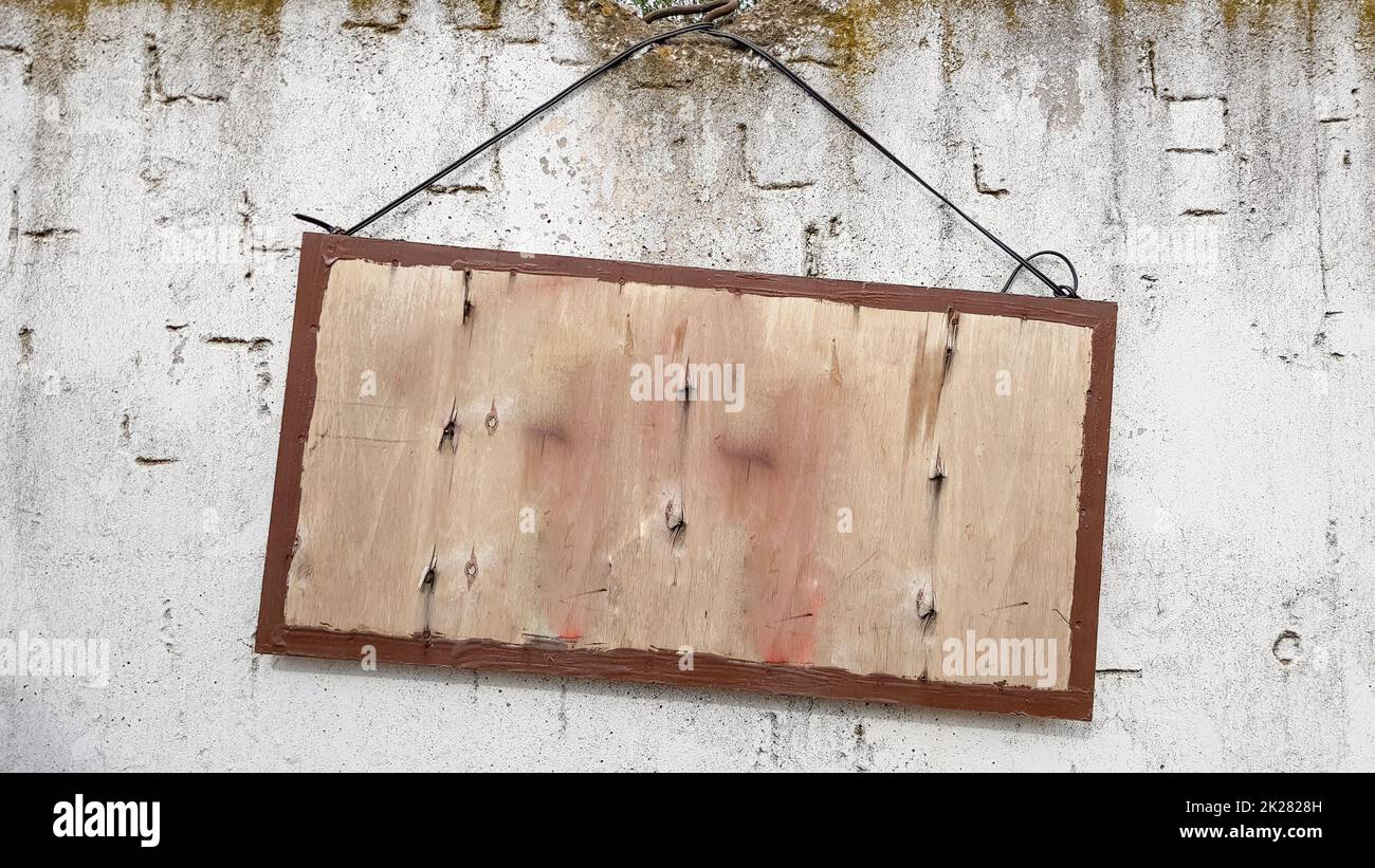 hanging wooden sign on a gray concrete wall. frame on a cement wall. A