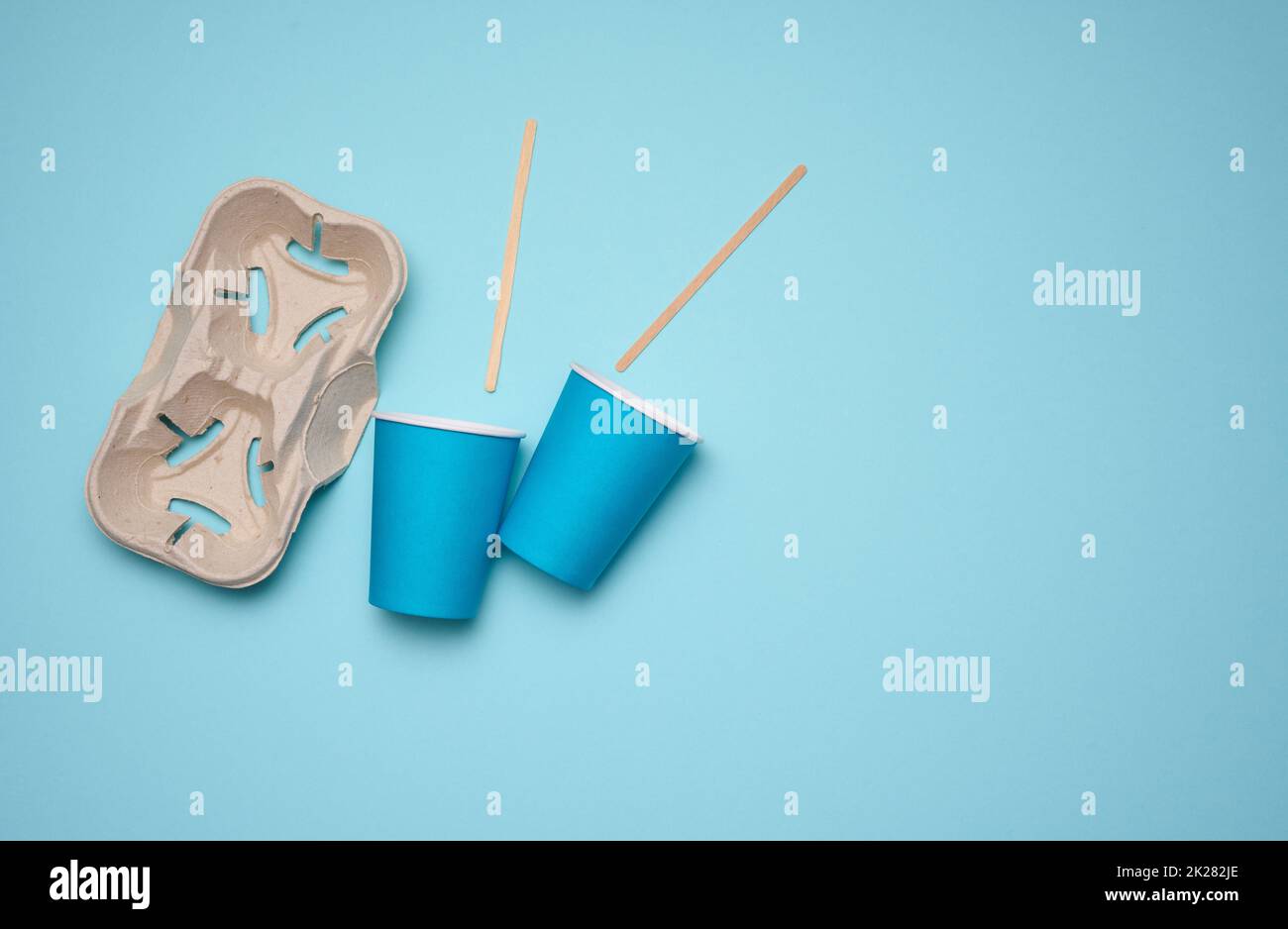 disposable blue paper cups, wood sticks and paper tray on blue