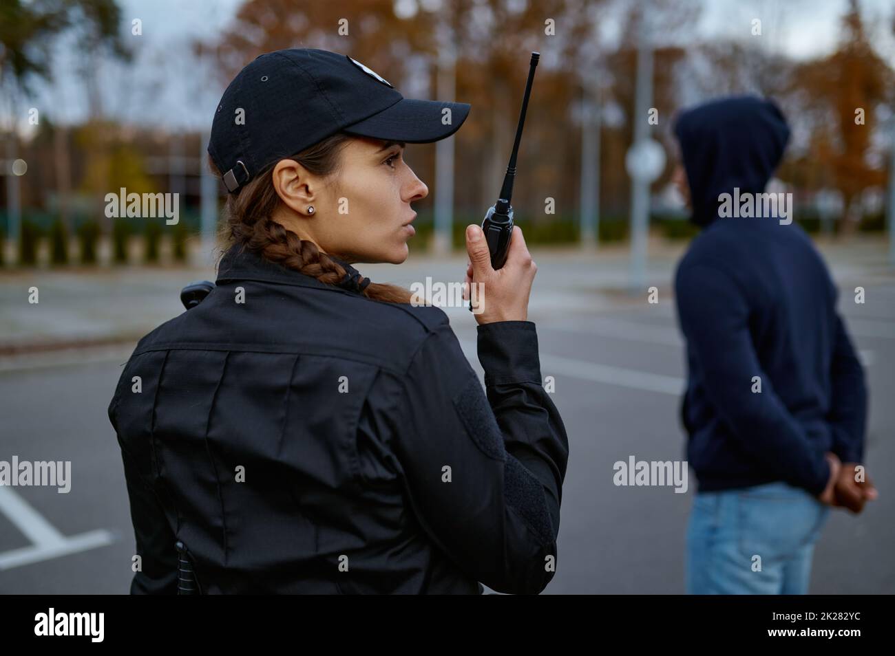 Woman cop using portable radio back view Stock Photo