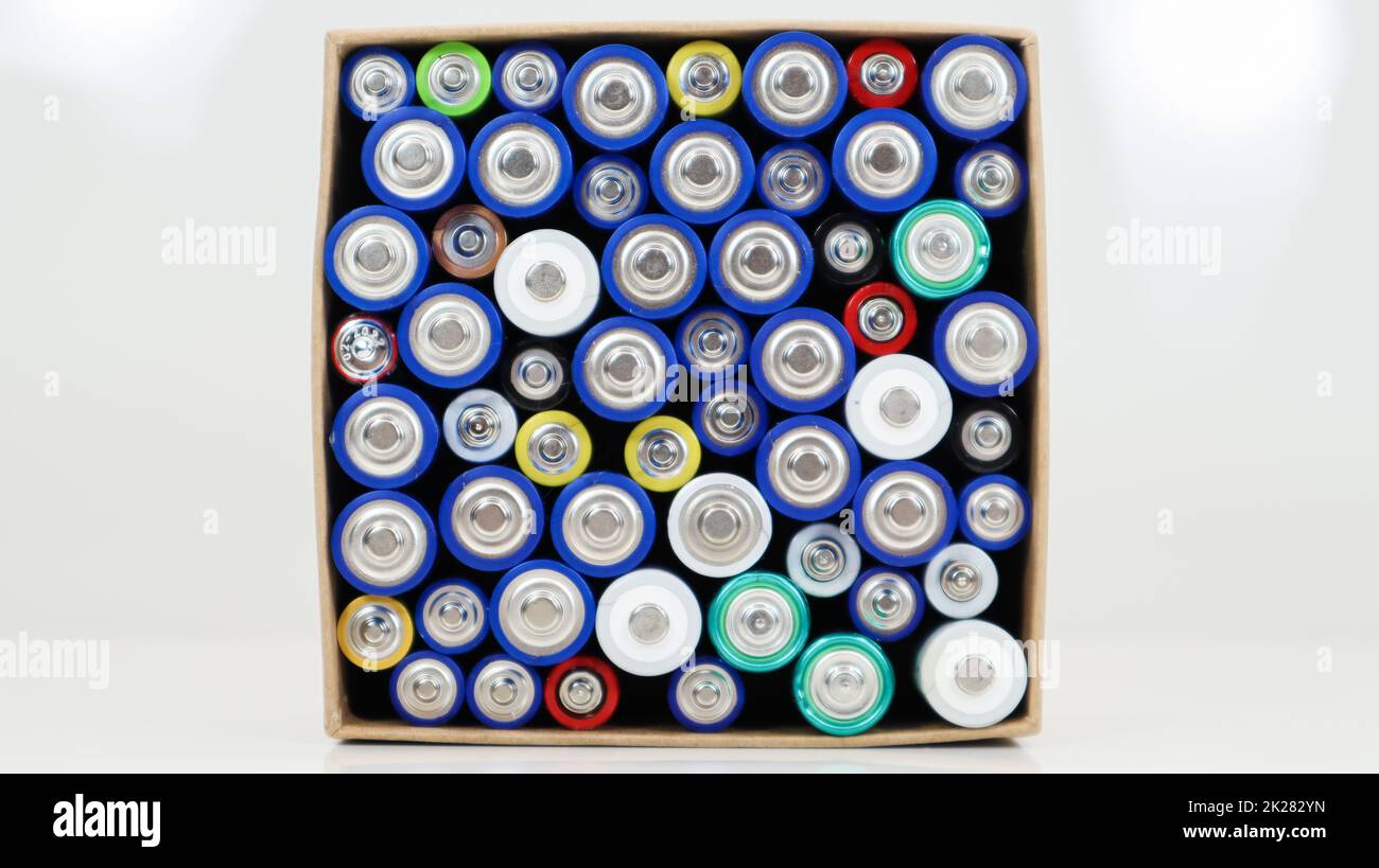 Top view of the background of AAA AA batteries and rechargeable batteries. Choice of batteries. Energy supply and recycling concept. Textures of electric elements packed close together in a box. Stock Photo