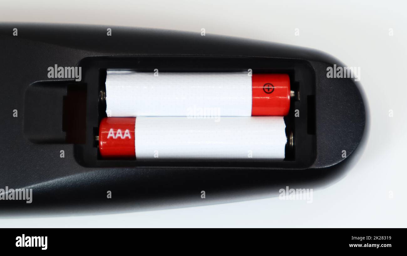 Black TV remote control with AAA alkaline batteries in red and white on a white background