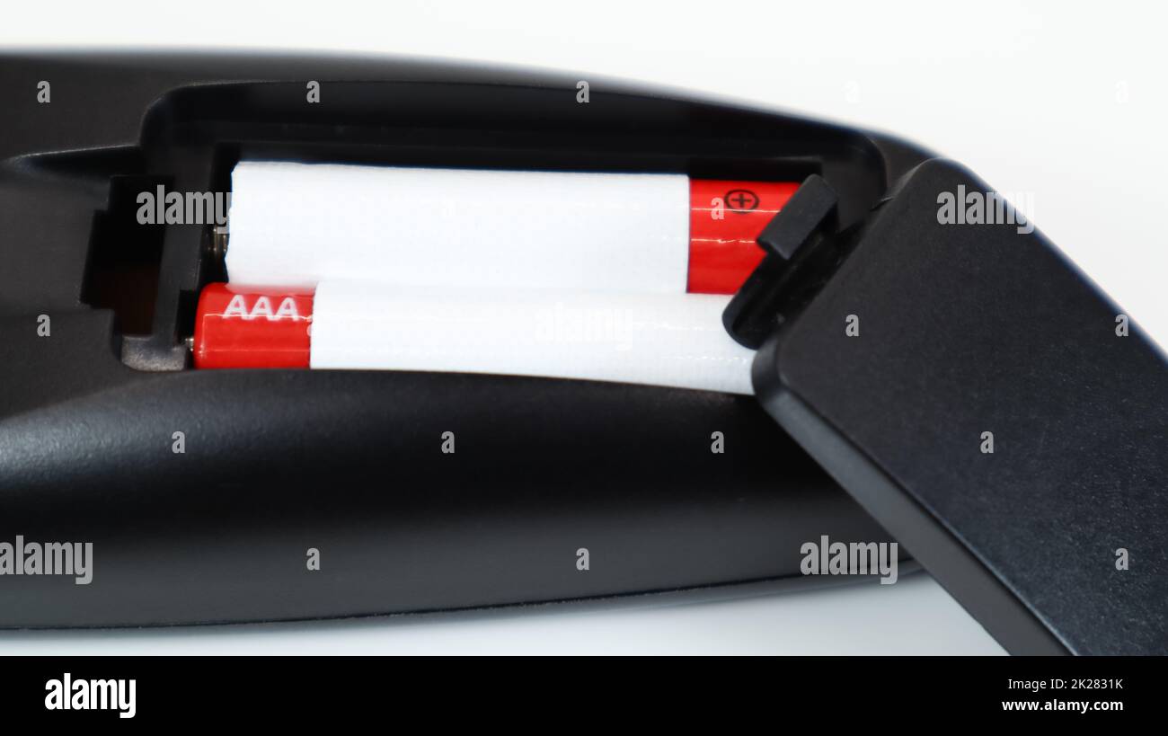 Black TV remote control with AAA alkaline batteries in red and white on