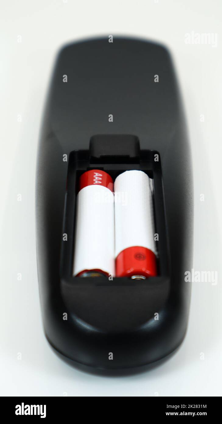 Black TV remote control with AAA alkaline batteries in red and white on