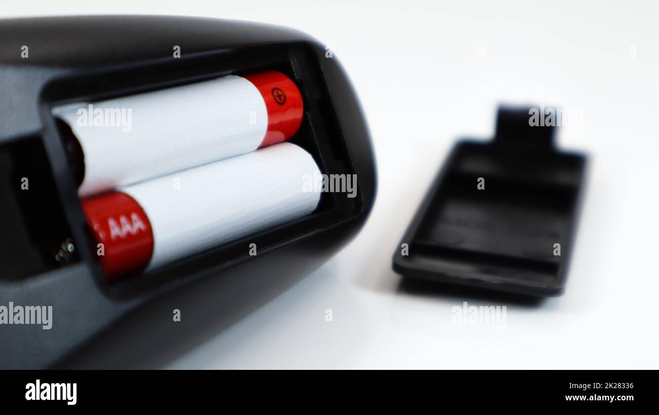 Black TV remote control with AAA alkaline batteries in red and white on