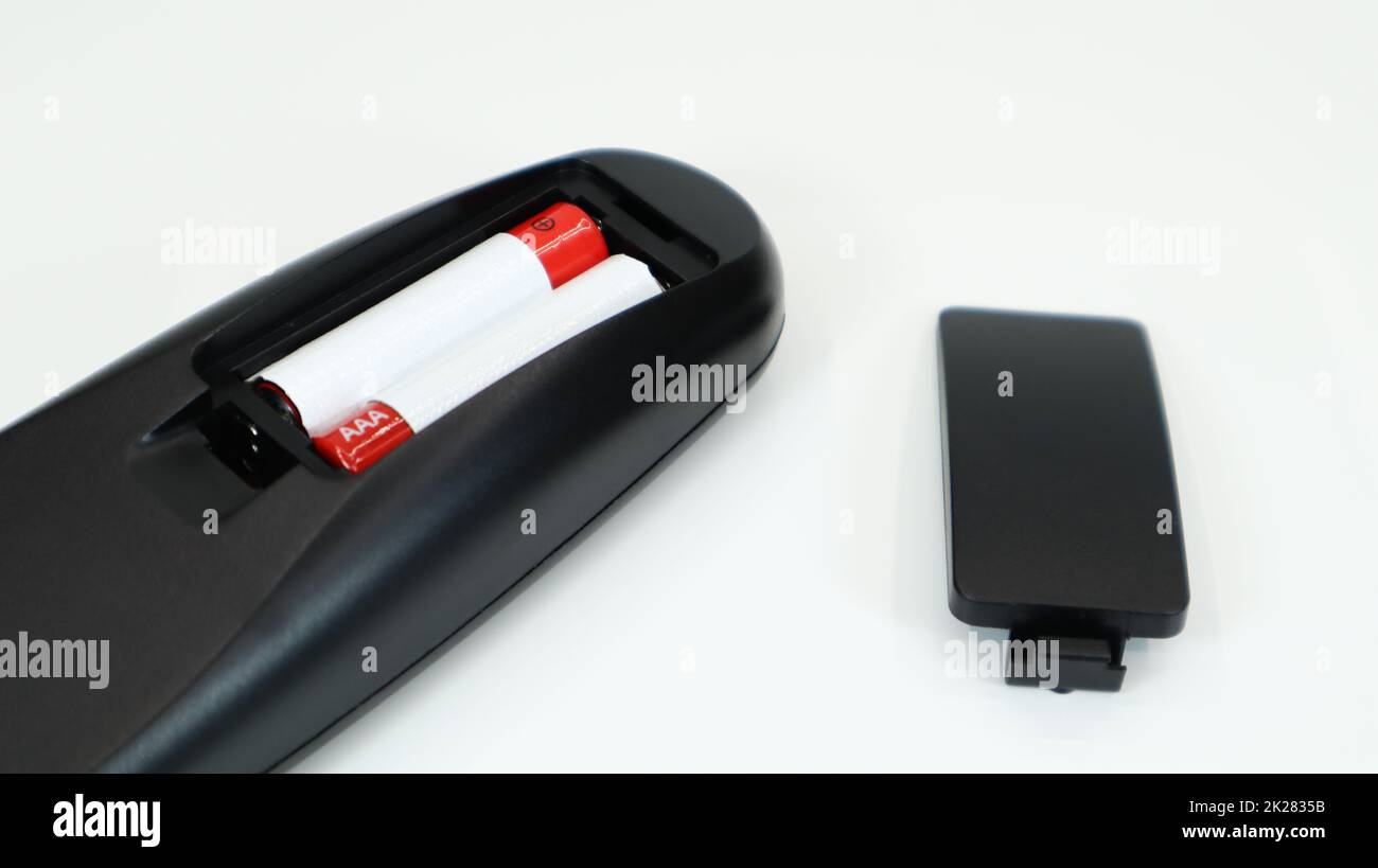 Black TV remote control with AAA alkaline batteries in red and white on