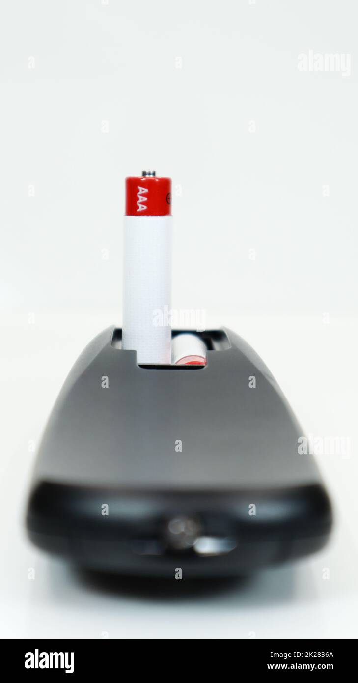 Black TV remote control with AAA alkaline batteries on a white