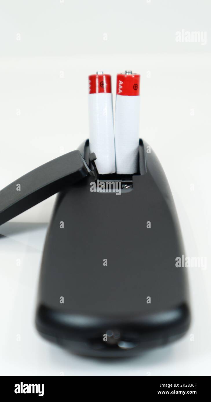 Black TV remote control with AAA alkaline batteries on a white