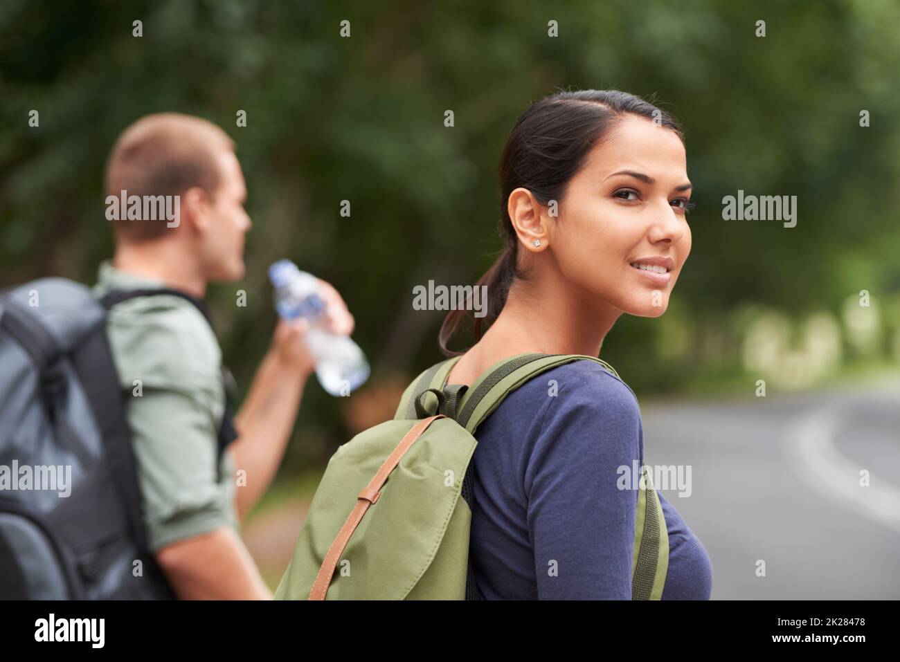 The goal of travel is to explore yourself. A candid image of a woman looking into the distance while her husband drinks water. Stock Photo