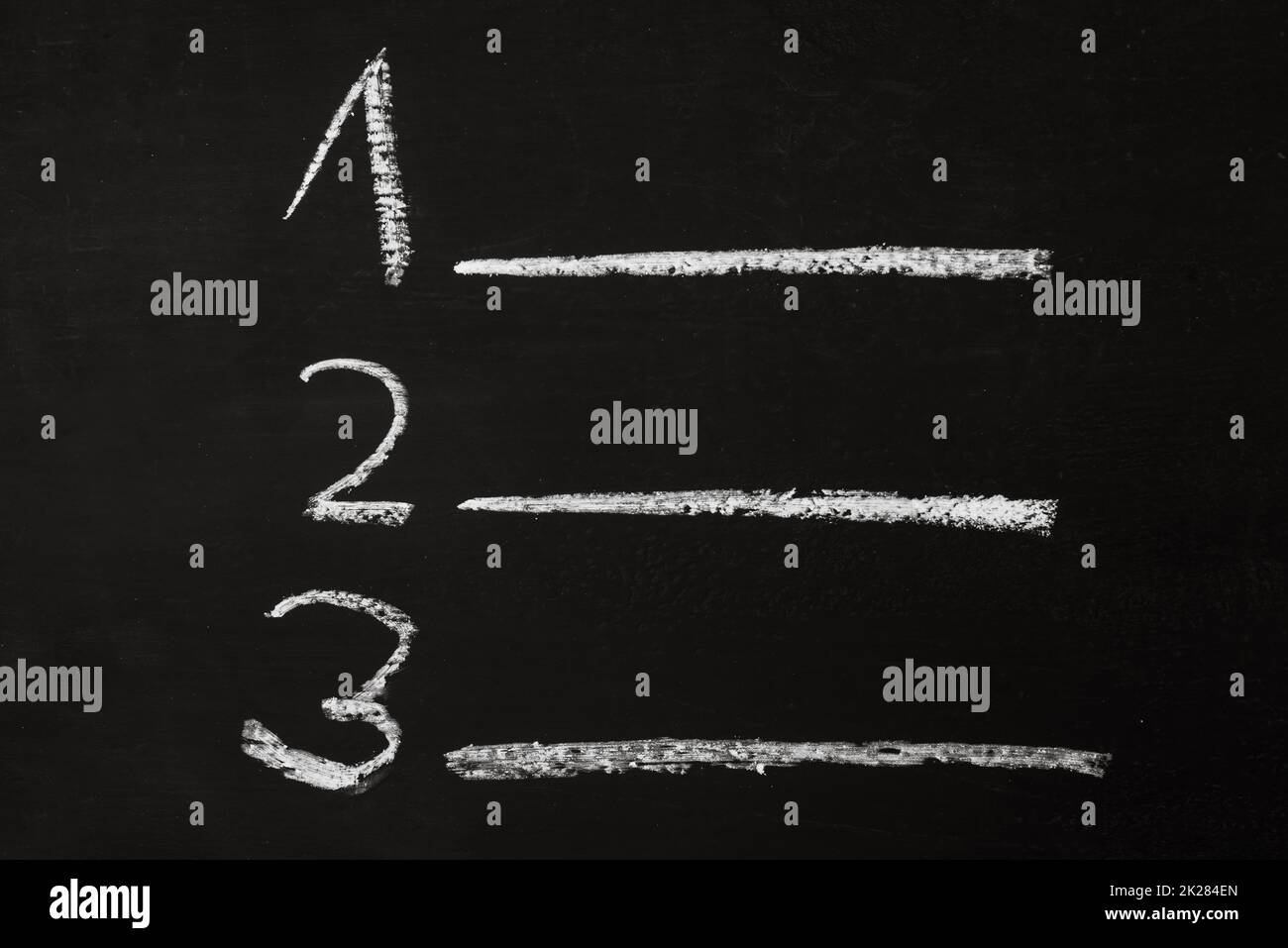 The numbers one, two and three are standing with lines on a chalkboard, lesson and presentation board, education concept, copy space Stock Photo