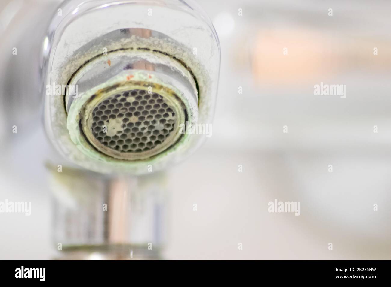 Old scaled faucet as calcified chrome handle in the bathroom needs
