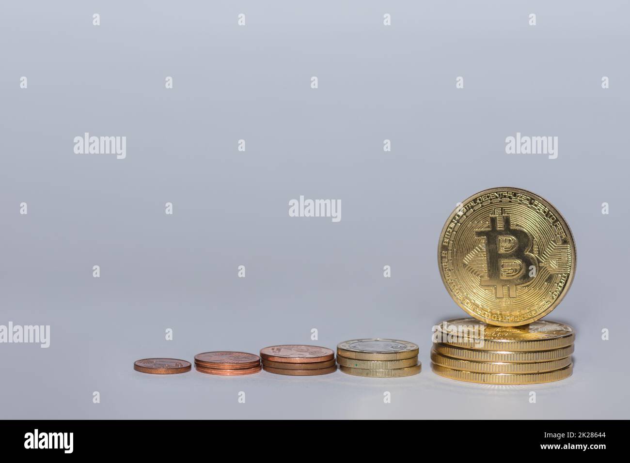 euro coins and bitcoins from crypto currency stacked in a row with gray Stock Photo