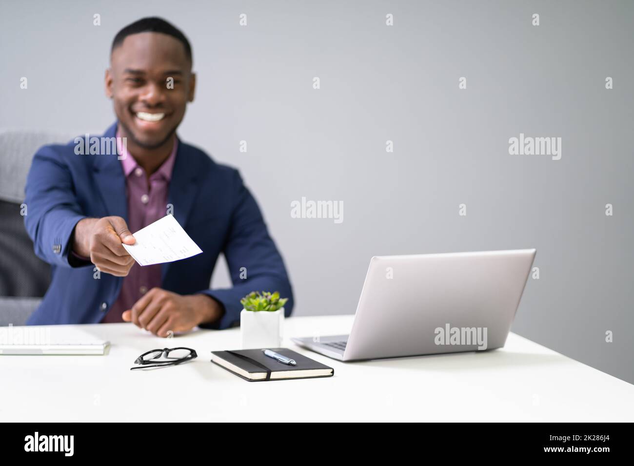 African Business Man Giving Paycheck Stock Photo