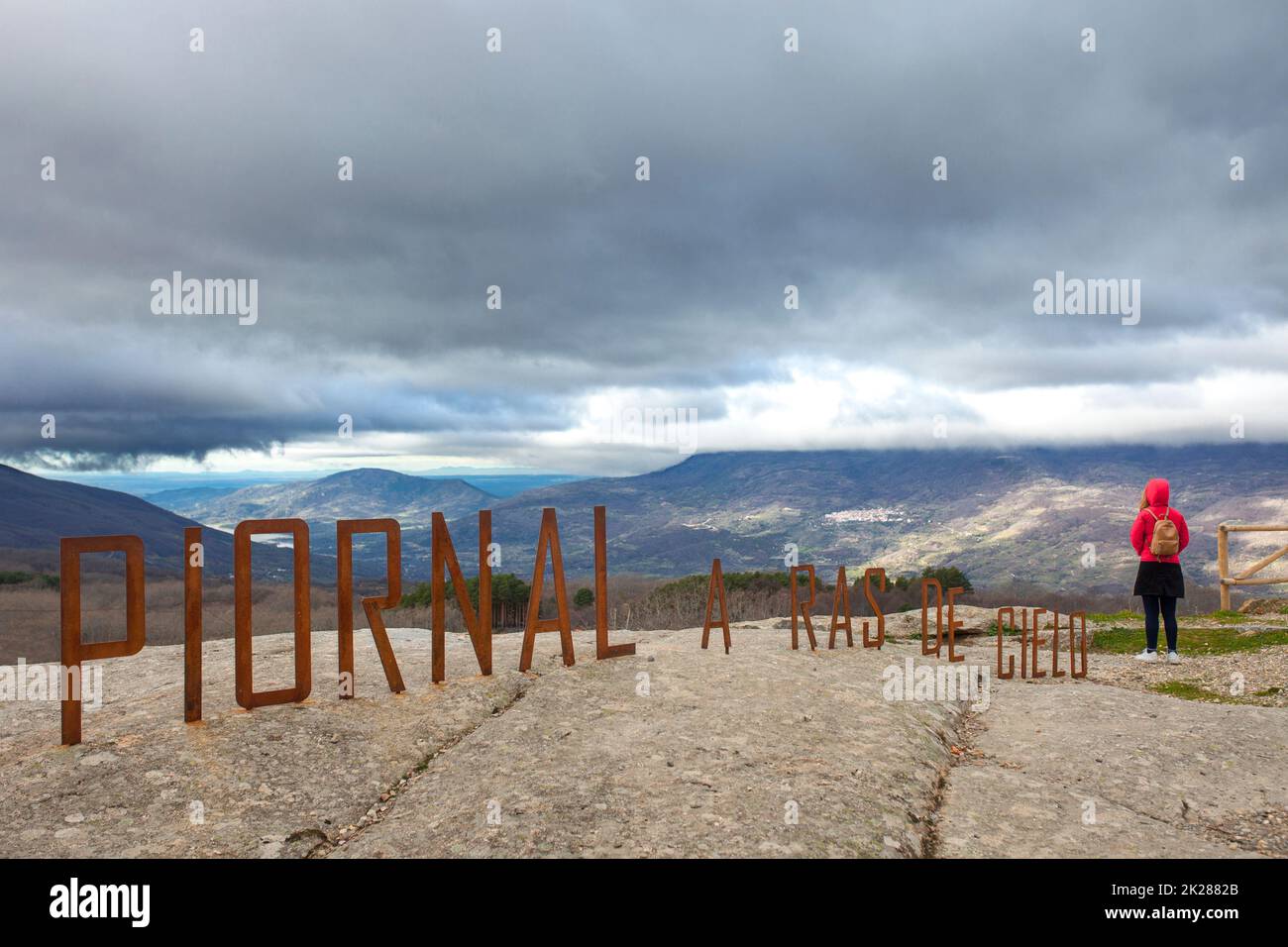 Woman observing skyscape from Piornal letters viewpoint. Caceres, Extremadura, Spain Stock Photo