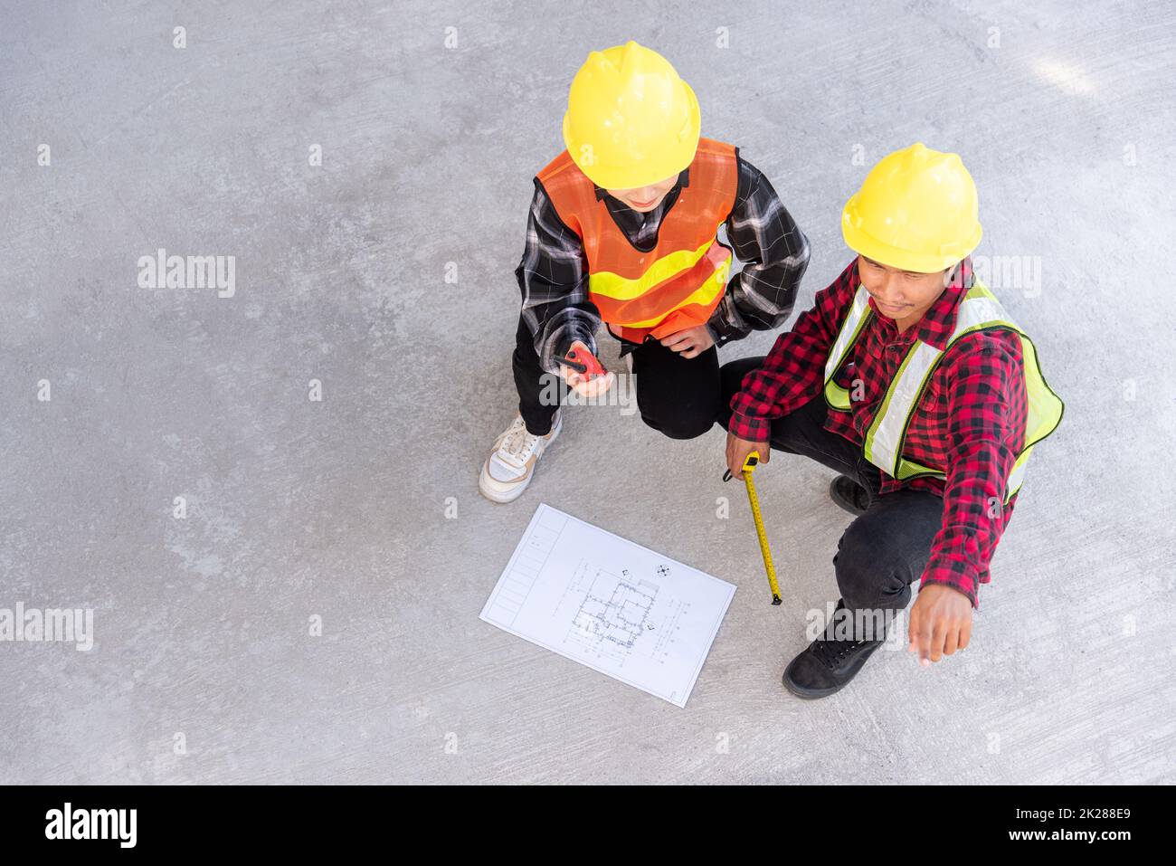 Architect and client discuss help create plan with blueprint of the building at construction site floor Stock Photo