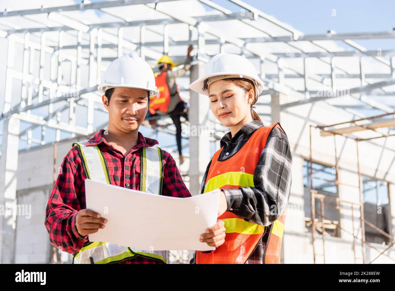 Two architect and client discussing help create plan with blueprint home building at construction site Stock Photo