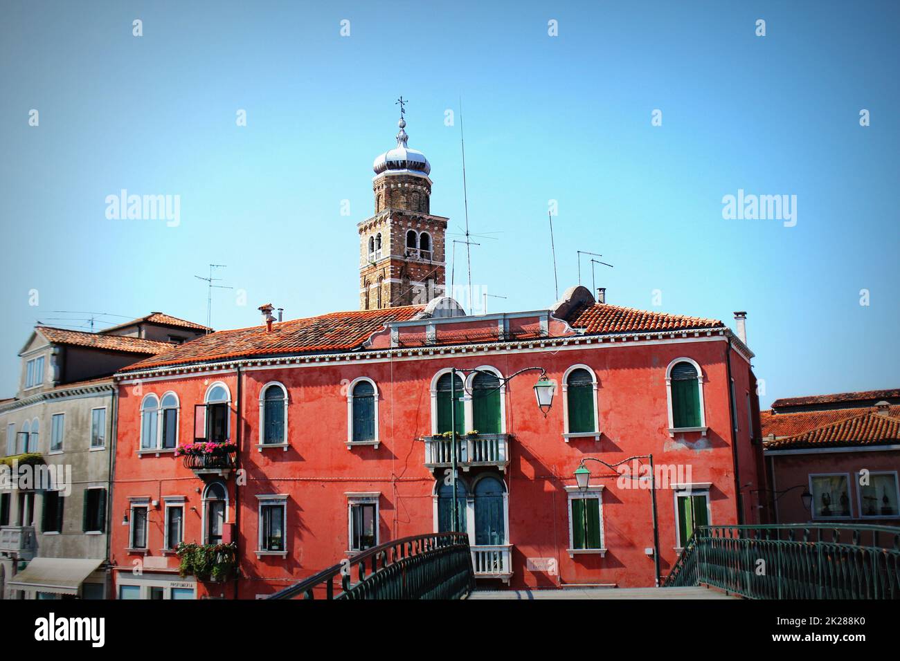 Colorful residential buildings and campanile of church San Pietro Martire in Burano island, Venice lagoon Stock Photo
