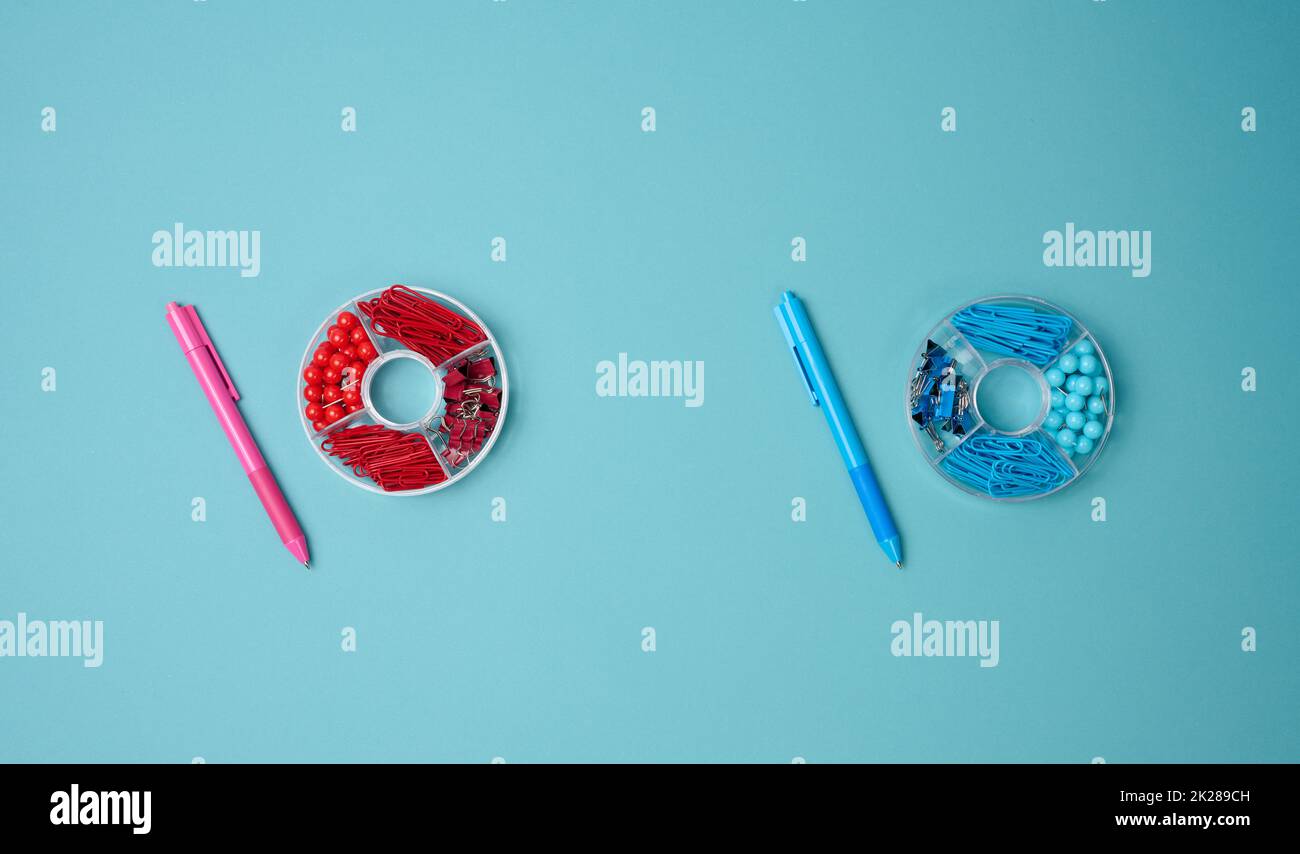 set of stationery objects: pen, paper clip, buttons and clip on a blue background. View from above Stock Photo