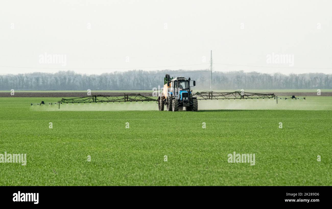 Tractor with a spray device for finely dispersed fertilizer. Stock Photo