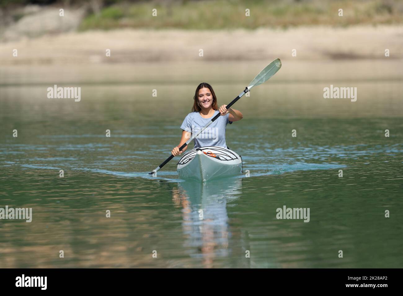 Happy woman kayaking rowing in a lake Stock Photo - Alamy