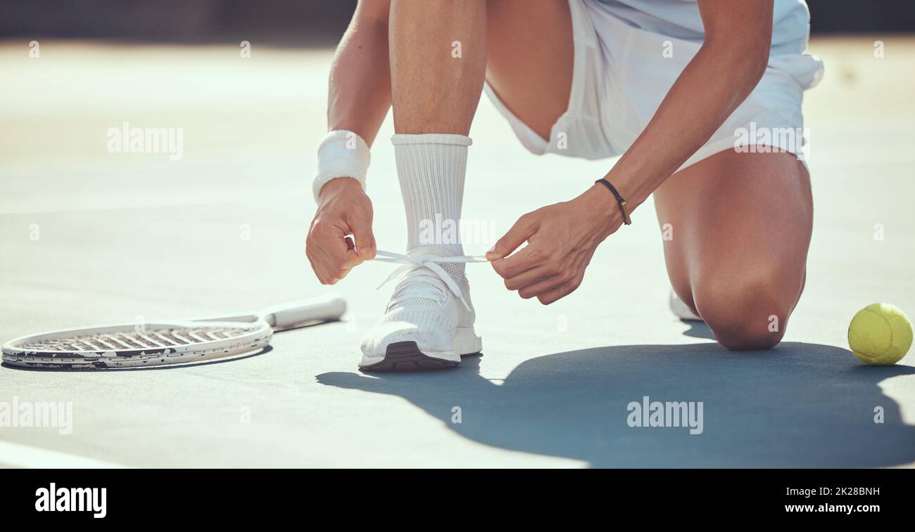 Tennis sports athlete tie shoes to prepare for exercise, fitness or competition training on tennis court. Player or man hands tying shoelaces ready Stock Photo