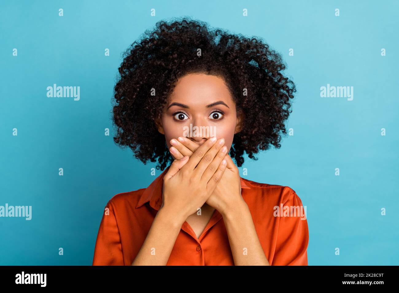 Portrait of worried nervous lady arms palms covering mouth mute quiet isolated on blue color background Stock Photo