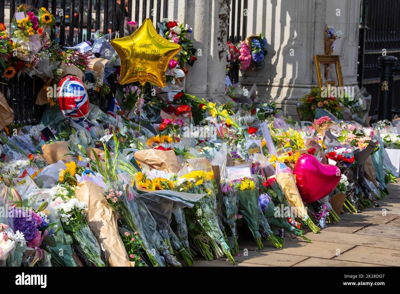 London, UK - September 9th 2022: Flowers and balloons left by well-wishers at Buckingham Palace in London, UK, in commemoration of Queen Elizabeth II, Stock Photo
