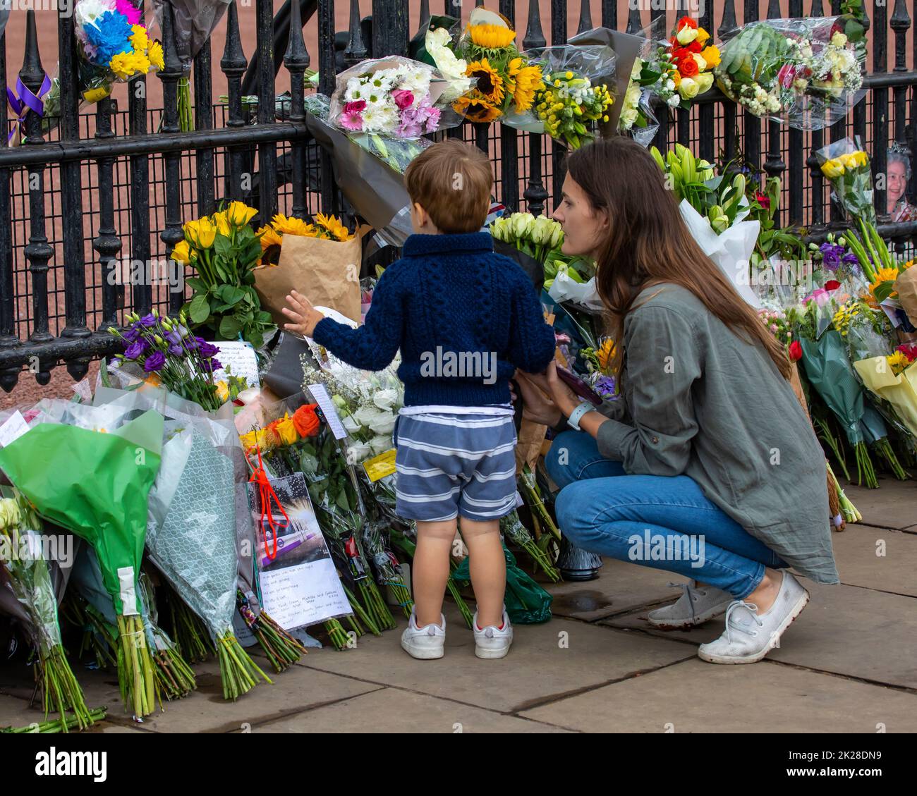 London, UK - September 9th 2022: A mother and child look at flowers left by well-wishers at Buckingham Palace in London, in memory of Elizabeth II, wh Stock Photo