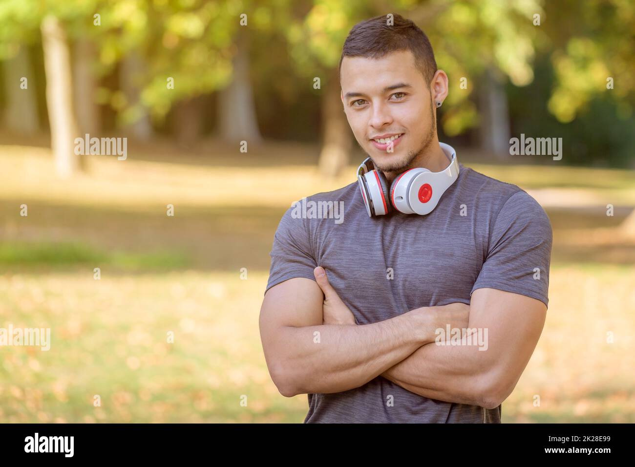 Smiling young latin man runner sports training fitness workout in a park copyspace copy space Stock Photo