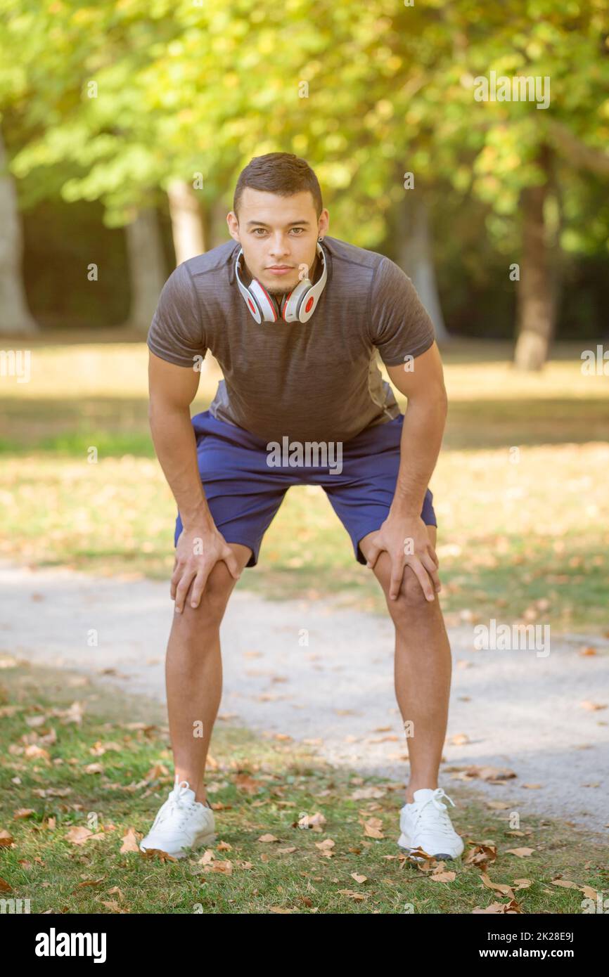 Runner sports training fitness young latin man ready start in a park portrait format Stock Photo