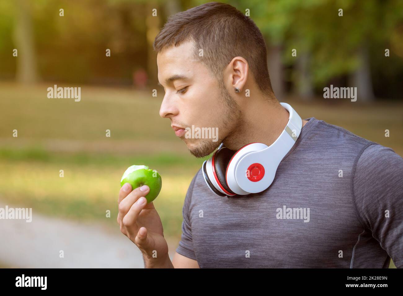 Young man eating an apple runner sports training workout fitness copyspace copy space Stock Photo
