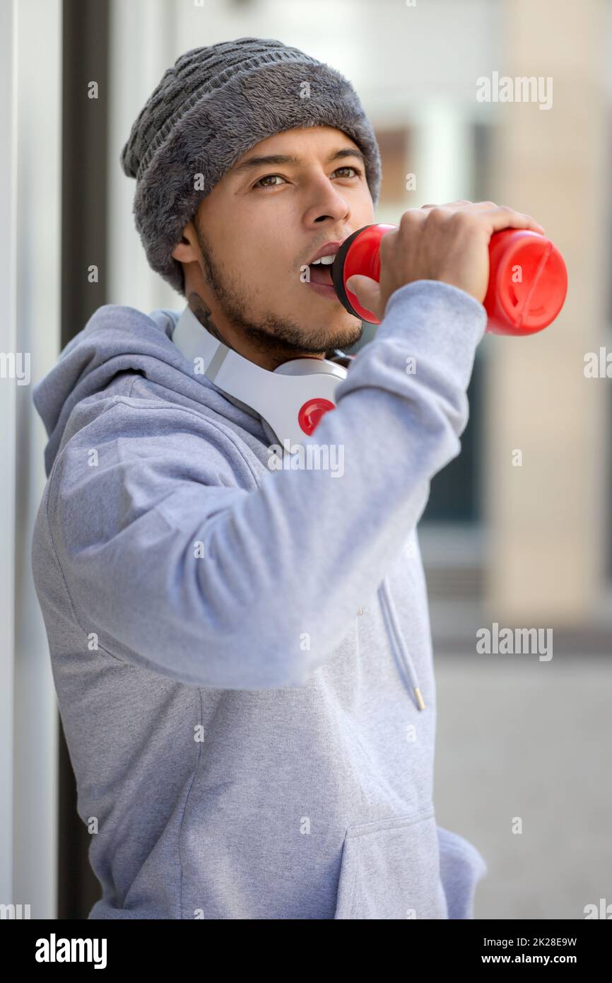 Drinking water young man runner portrait format winter cold sports training fitness Stock Photo