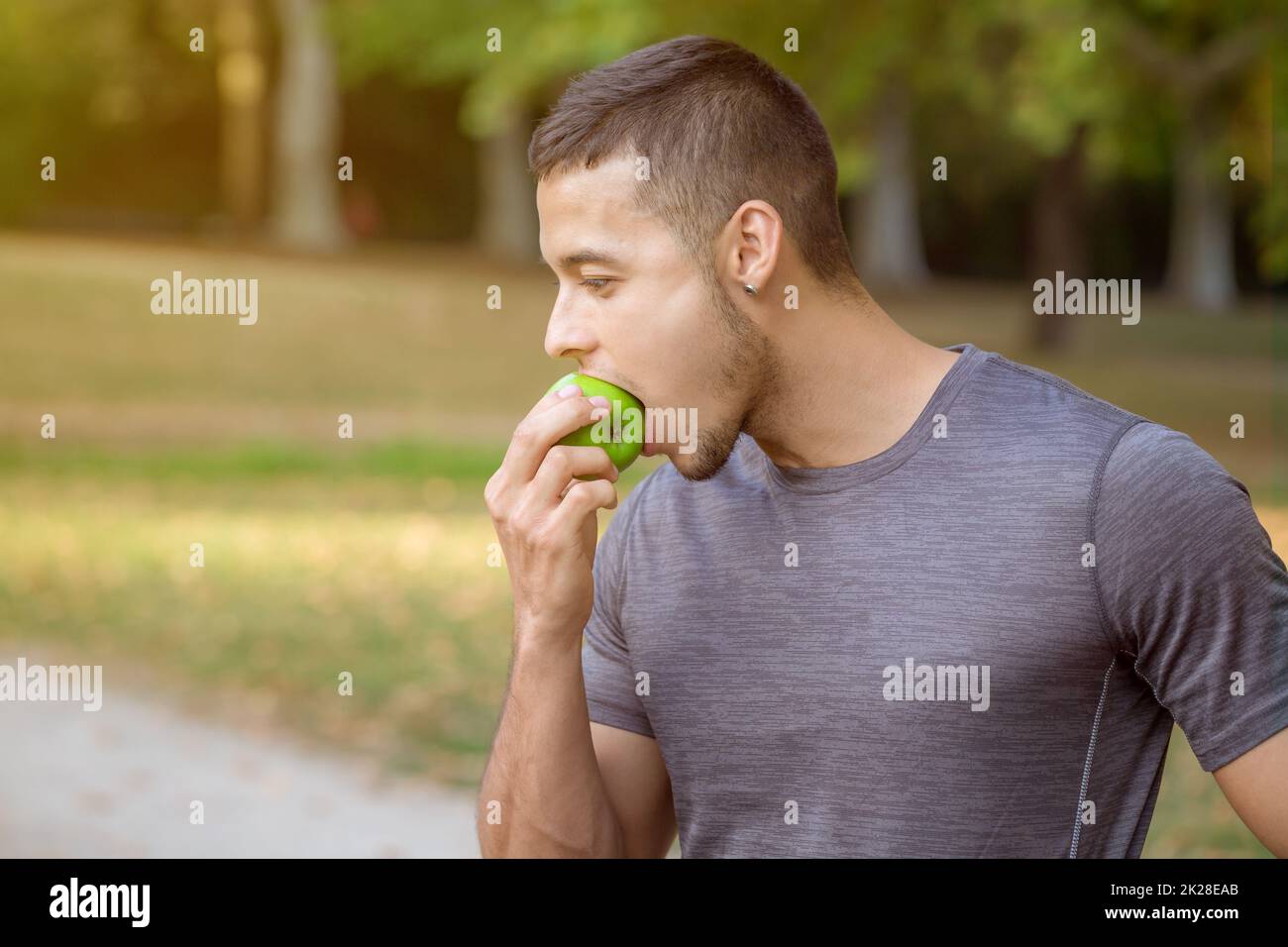 Young man eating apple in a park copyspace copy space runner sports training Stock Photo