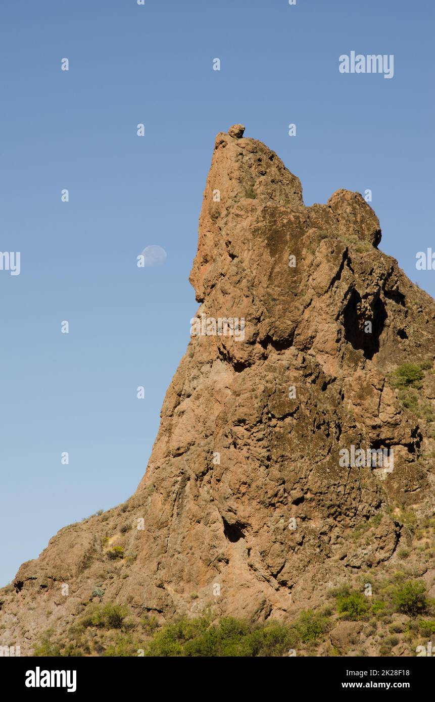Rocky cliff and moon in the background. Stock Photo