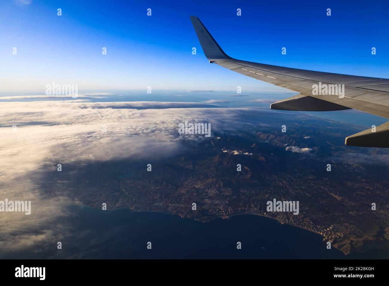 The view of the horizon line across the blue sky on the airplane during the evening day light Stock Photo