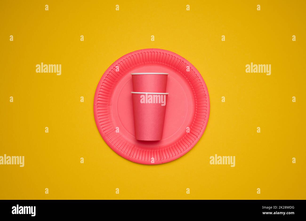red paper cups and plates on a yellow background. Recyclable garbage