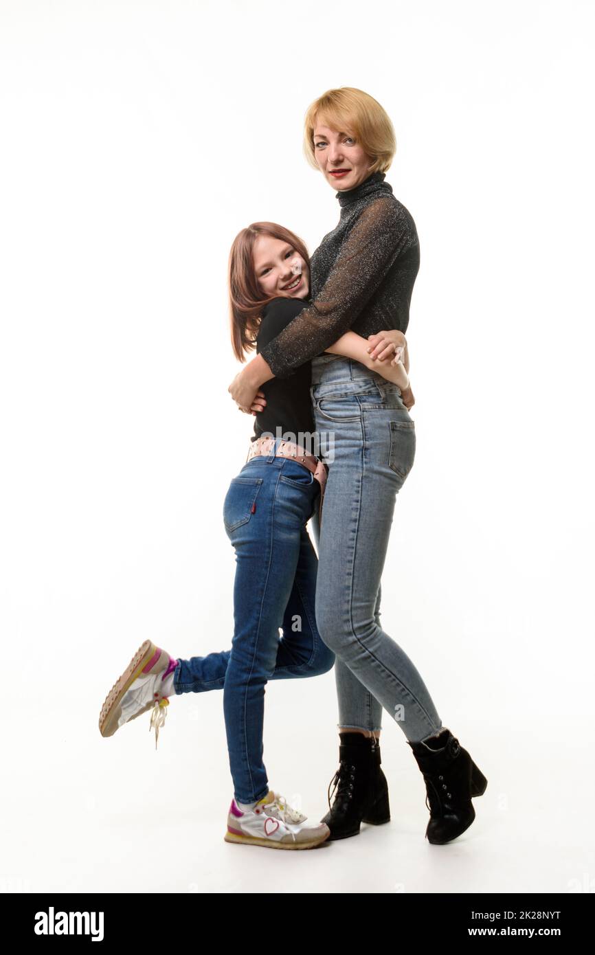 A happy daughter hugs her mother, both happily look into the frame Stock Photo