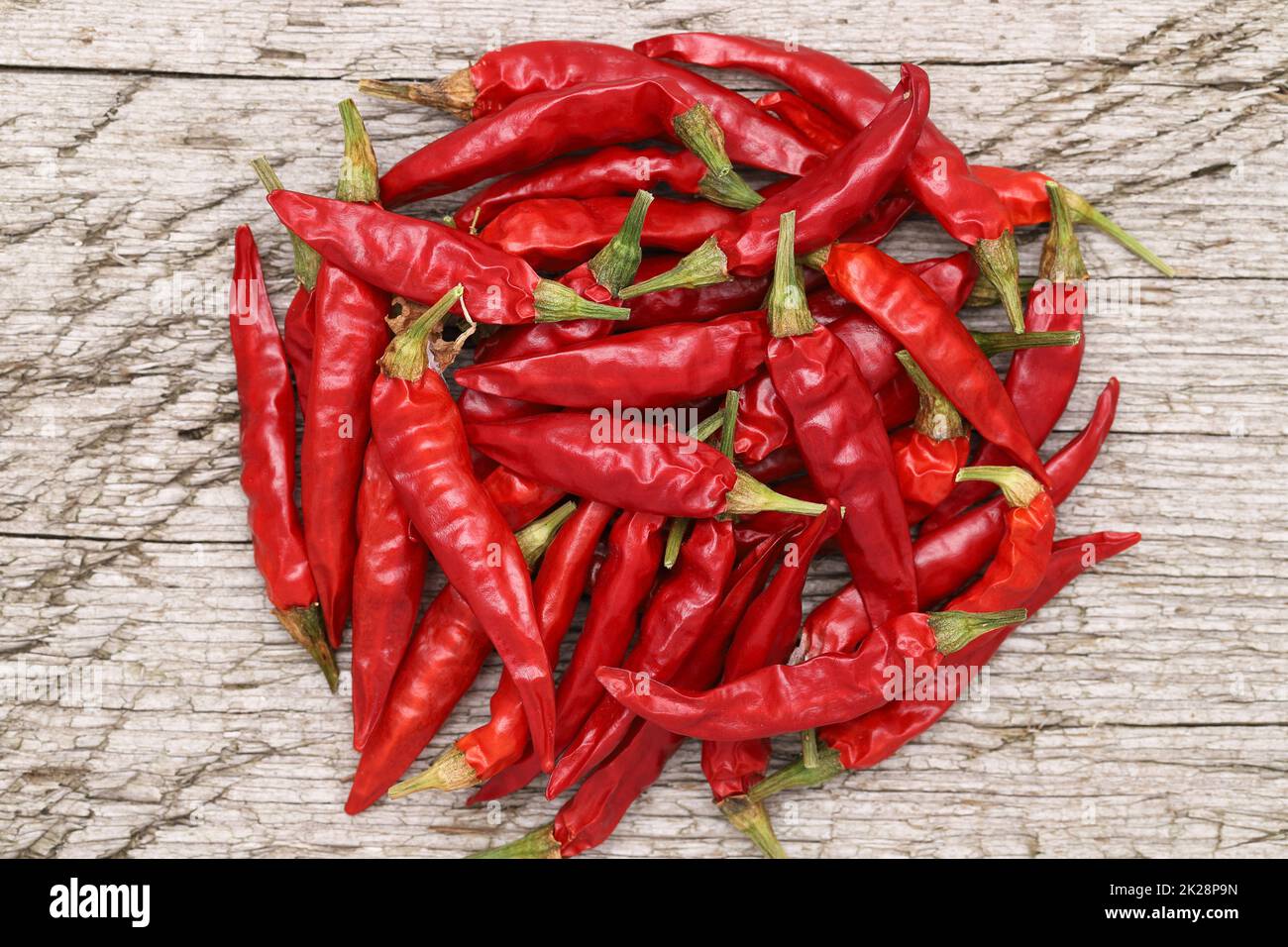 stack of red chili pepper plants on grungy wooden background Stock Photo