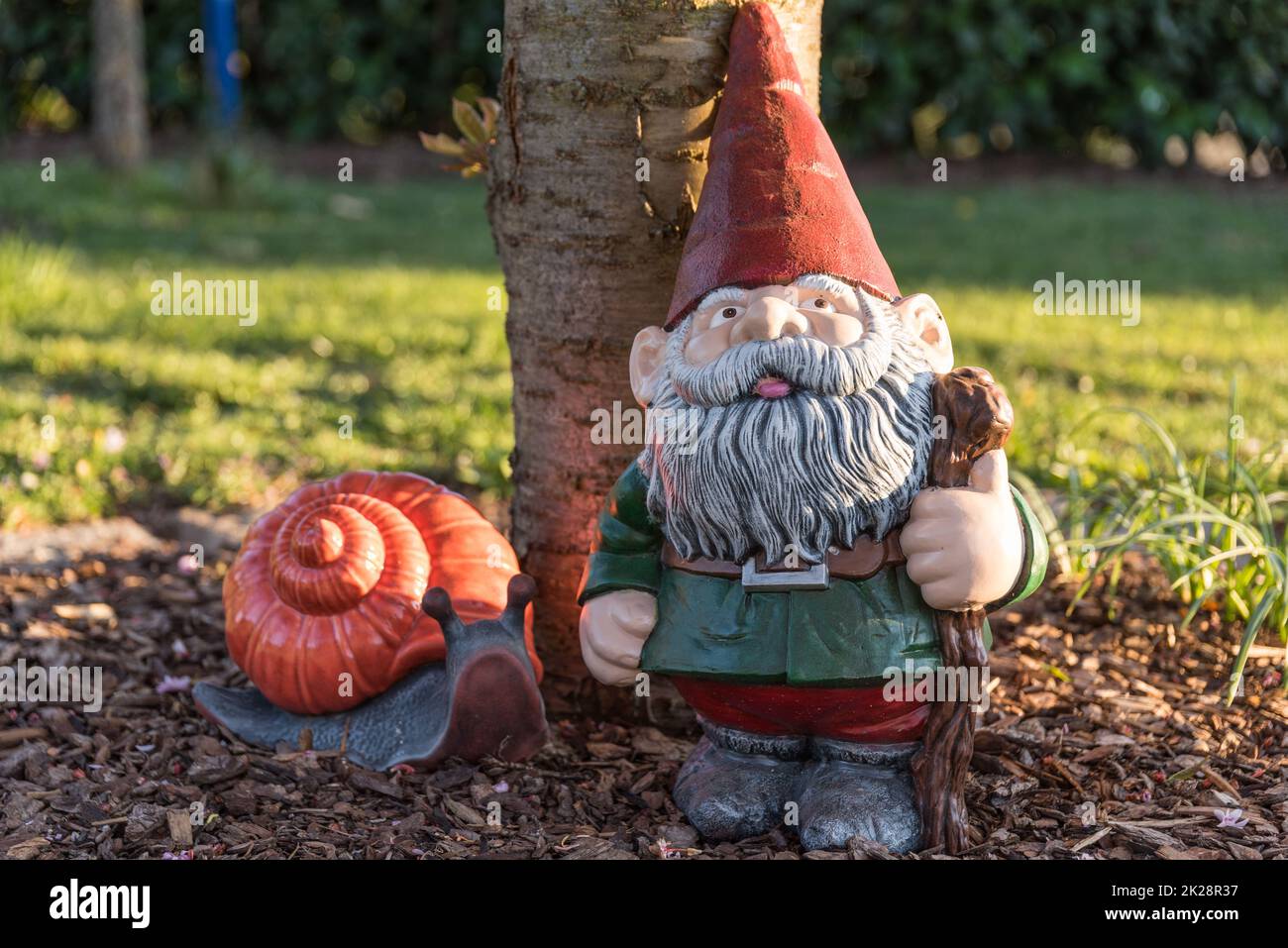painted garden gnome and snail in the garden as a decoration, garden design Stock Photo