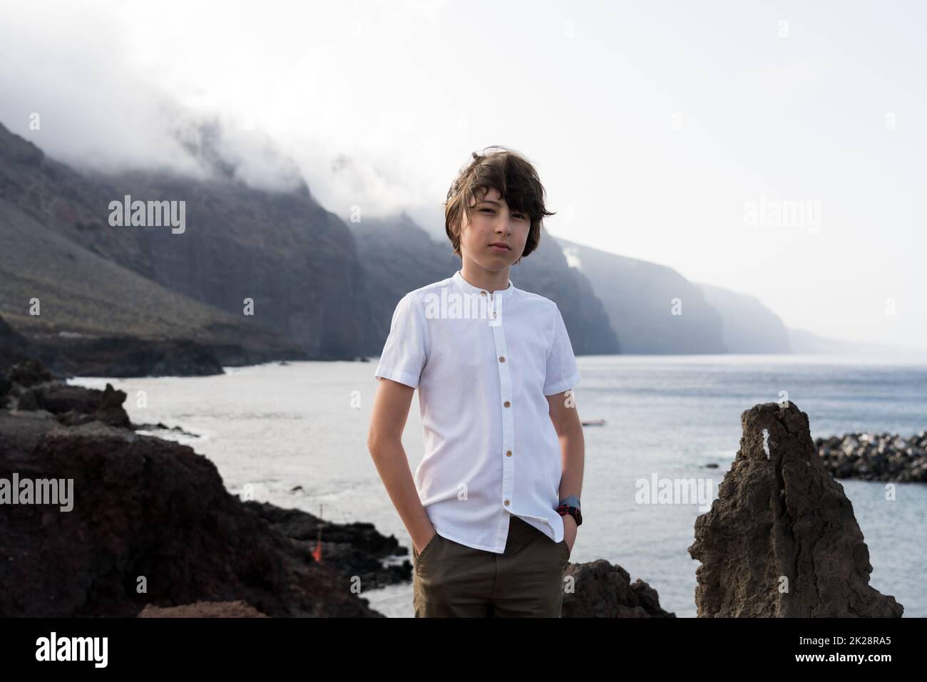 Portrait of a teenager against the backdrop of the Los Gigantes cliffs. Tenerife. Canary Islands. Spain. Stock Photo