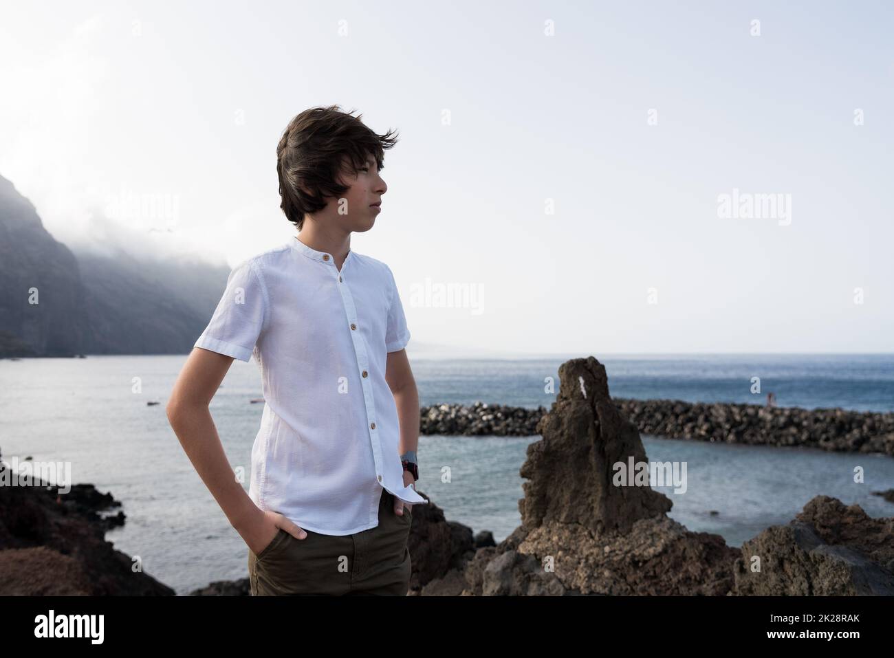 Portrait of a teenager against the backdrop of the Los Gigantes cliffs. Tenerife. Canary Islands. Spain. Stock Photo