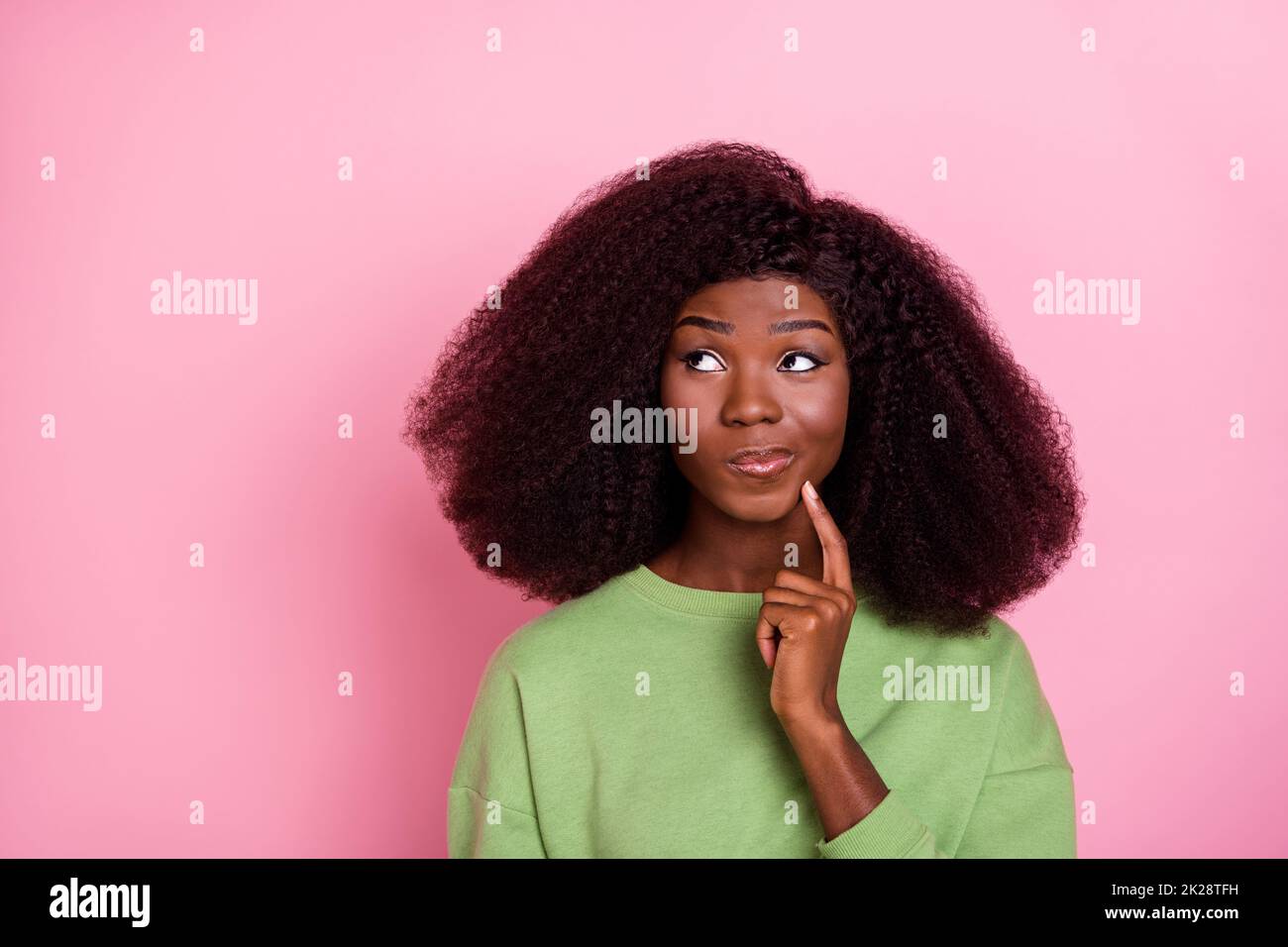 Photo of unsure big hairdo brunette lady think look up wear green sweatshirt isolated on pink color background Stock Photo