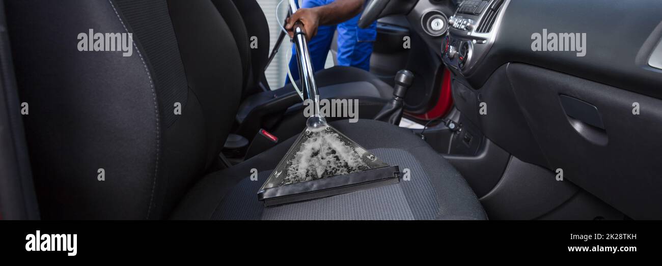 Male using professional steam vacuum for dirty car interior