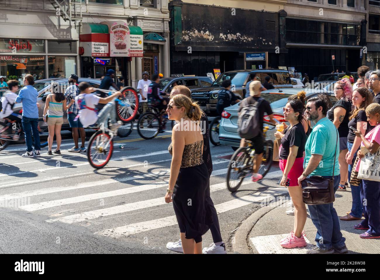 Hundreds of people on bicycles and motorized scooters take over the West 23rd Street road and sidewalk in Chelsea in New York as they travel in a pack on Sunday, September 18, 2022. (© Richard B. Levine) Stock Photo