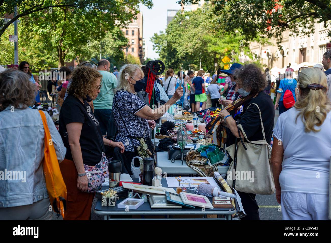 Shoppers search for bargains at the humongous annual Penn South Flea Market in the New York neighborhood of Chelsea on Saturday, September 17, 2022. The flea market appears like Brigadoon, only once every year, and the residents of the 20 building Penn South cooperative have a closet cleaning extravaganza. Shoppers from around the city come to the flea market which attracts thousands passing through.  (© Richard B. Levine) Stock Photo