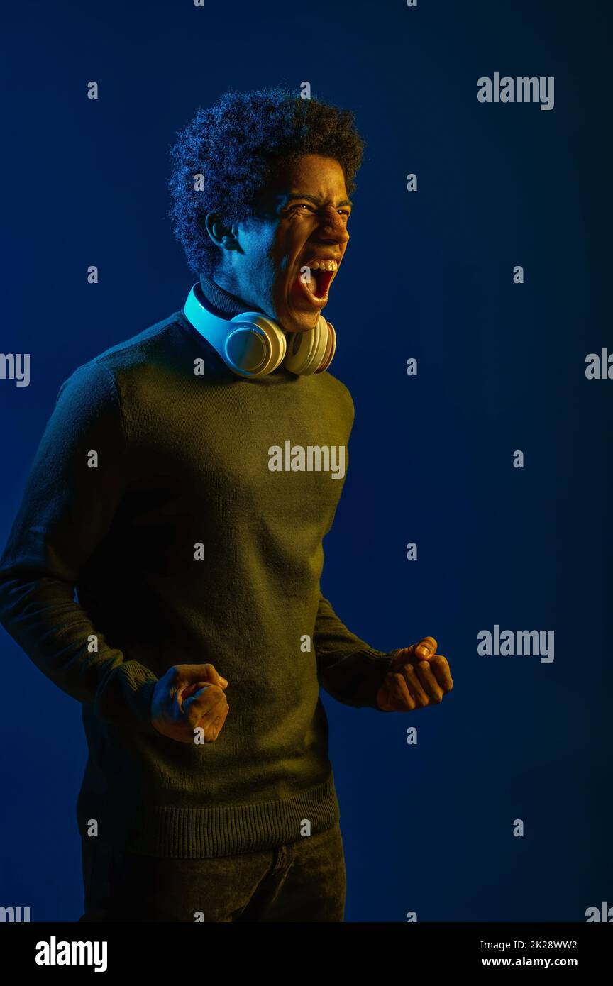 Man in headset screaming over dark studio background Stock Photo