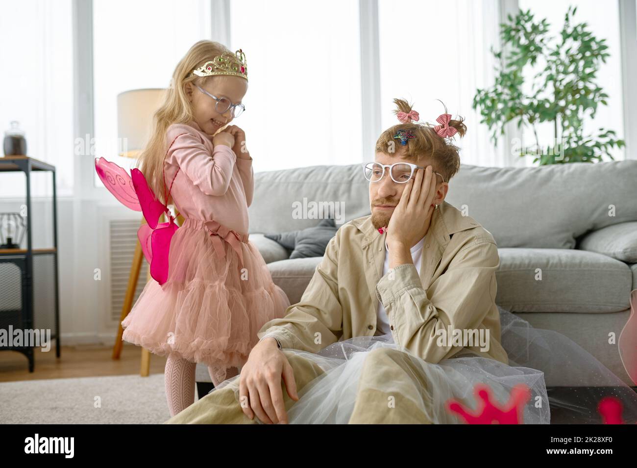 Tired father wearing having fun with daughter Stock Photo