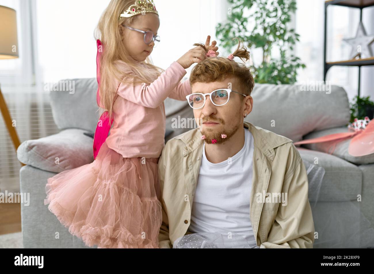 Daughter create funny hairstyle to father Stock Photo